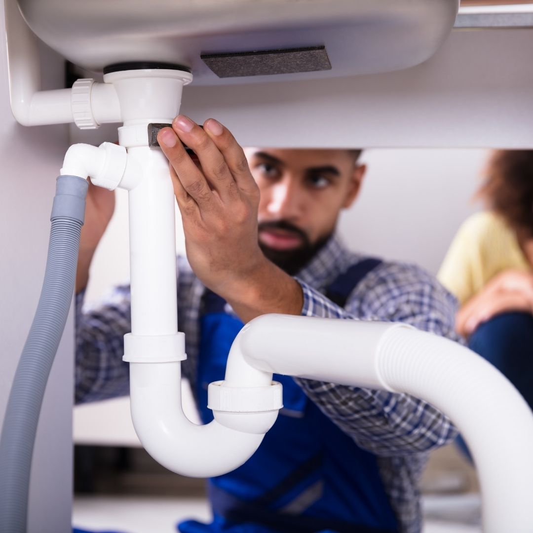 A man fixing a sewer line pipe